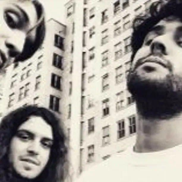 Alternative rock band 95 Behind with different expressions standing in front of a building with windows. | MOON MUTT Recording Studio