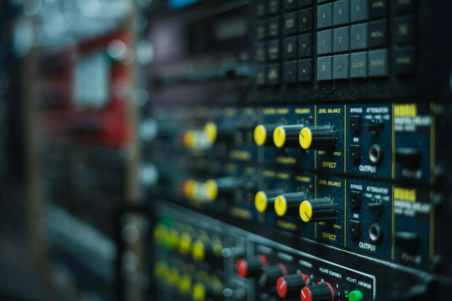 Close-up of a sound mixing board at MOON MUTT Recording Studio in Roswell, New Mexico, with various knobs and sliders for audio control. | MOON MUTT Recording Studio