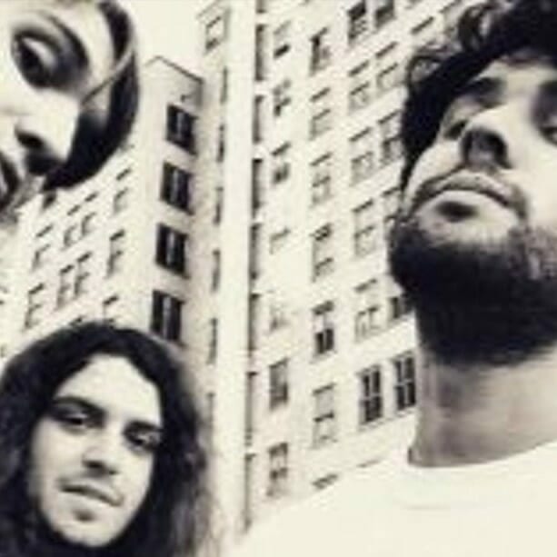 Alternative rock band 95 Behind with different expressions standing in front of a building with windows. | MOON MUTT Recording Studio